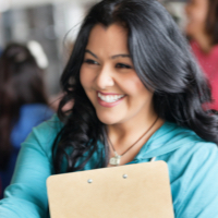 woman smiling while holding clipboard